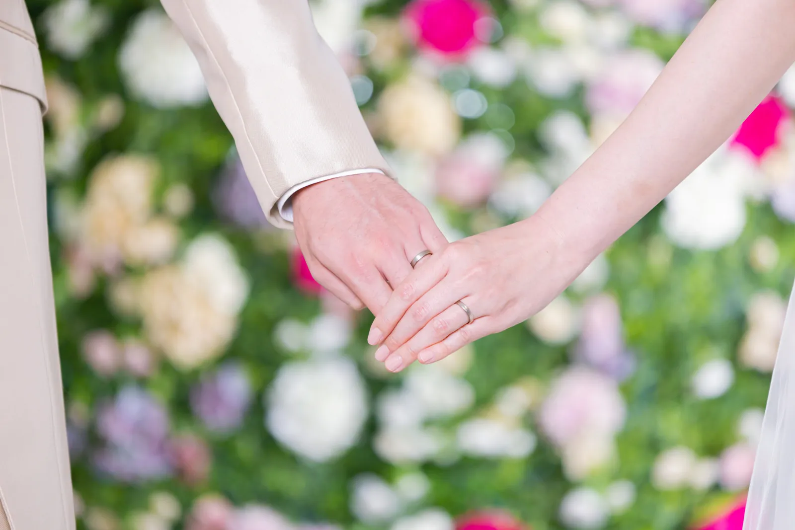 手を繋いで歩む新郎新婦