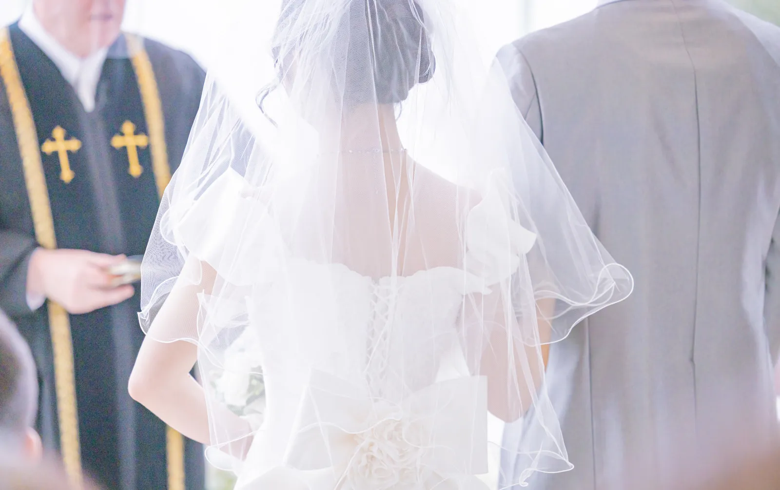 式を挙げる新郎新婦の後ろ姿